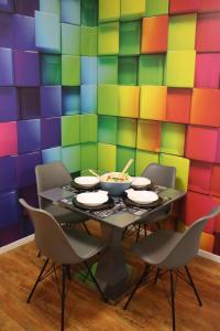 een tafel met stoelen en een kleurrijke muur bij Downtown Cube Apartment in Boedapest