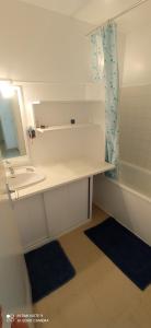uma casa de banho com um lavatório, um espelho e uma banheira em Appartement T3 em Valbonne