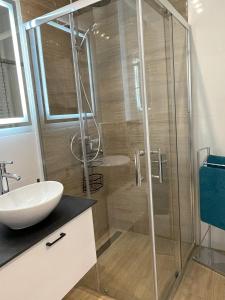 a bathroom with a glass shower and a sink at Wygodne Mieszkania Nova Mikołowska 135 in Katowice +14 photos