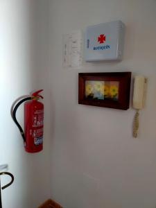 een brandkraan aan een muur naast een telefoon bij Los Girasoles in Olvera