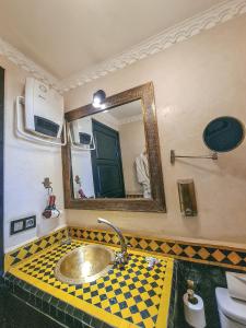 un baño con lavabo y espejo en Riad Jaime, en Marrakech