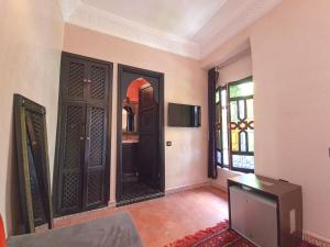 sala de estar con 2 puertas y TV en Riad Jaime, en Marrakech