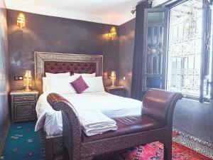 una camera con un letto e una sedia e una finestra di Riad Jaime a Marrakech