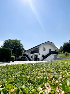 a building in the background with a field of plants at Apartments Sole in Podčetrtek