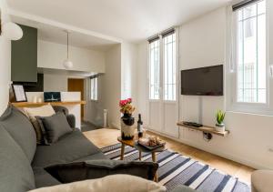 sala de estar con sofá y TV en Élégance & Design Paris Center, en París