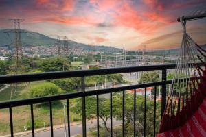 een balkon met een hangmat en uitzicht op de stad bij Apartamento con vistas en Cali 