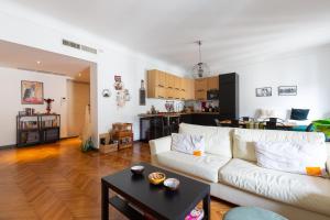 een woonkamer met een witte bank en een tafel bij Moscova Cosy Apartment in Milaan
