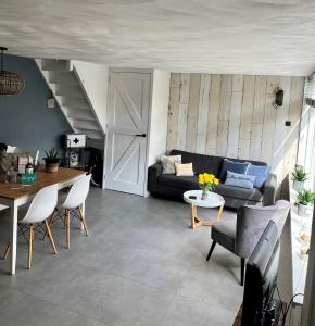 a living room with a couch and a table at HuisjehurenEgmond in Egmond aan Zee +13 photos