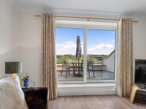 a living room with a sliding glass door leading to a balcony at Apartment 394 - Clifden in Clifden