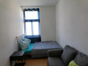 Cette chambre comprend un lit, un canapé et une fenêtre. dans l'établissement Central City Apartment 131, à Vienne
