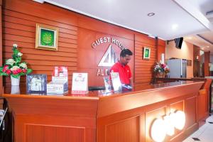 a man standing at the counter of a fast food restaurant at Capital O 142 Hotel Al Furqon Syariah in Palembang