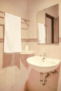 a bathroom with a sink and a mirror at Capital O 142 Hotel Al Furqon Syariah in Palembang