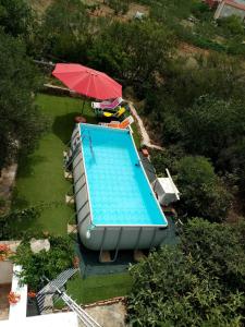 an overhead view of a swimming pool with an umbrella at Dalmatian in Bilice