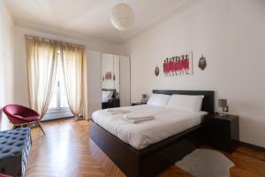 een slaapkamer met een groot bed en een rode stoel bij Moscova Cosy Apartment in Milaan