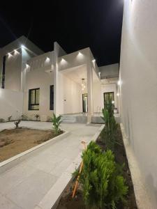 ein großes weißes Haus mit einem Innenhof in der Nacht in der Unterkunft أعناب الفندقية in Baljurashi