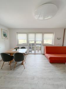 Apartments Sole في بوتْشيترتيك: غرفة معيشة مع أريكة حمراء وطاولة