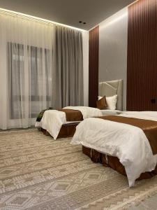 a hotel room with two beds in a bedroom at أعناب الفندقية in Baljurashi