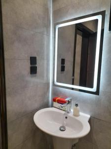 a bathroom with a sink and a mirror at أعناب الفندقية in Baljurashi