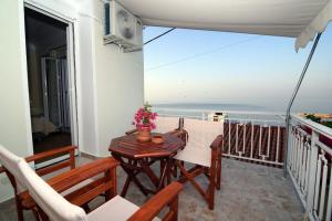 a balcony with a table and chairs and a view of the ocean at Plataneli House in Plomarion +9 photos