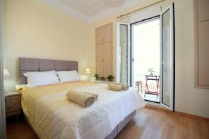 a bedroom with a large bed and a large window at Plataneli House in Plomarion