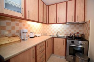 a kitchen with wooden cabinets and a sink and a stove at Plataneli House in Plomarion