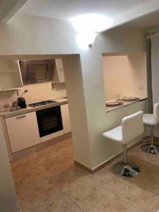 eine Küche mit zwei weißen Stühlen in einem Zimmer in der Unterkunft Mini appartamento” La Casetta” in Cosenza