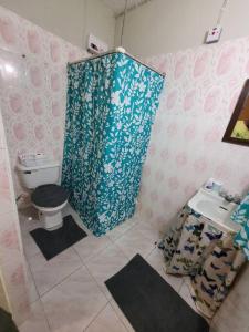 een badkamer met een toilet en een douchegordijn bij Serenity Heights in Ewarton