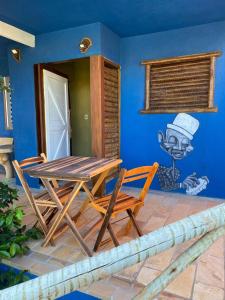 a table and chairs in a room with a blue wall at Pousada Nascer da Lua in Fortim