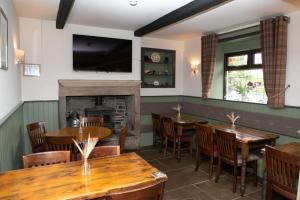 un restaurante con mesas y sillas y una chimenea en The New Rushcart Inn & Country Dining, en Sowerby Bridge