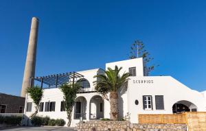 een wit gebouw met een palmboom ervoor bij Scorpios Beach in Monolithos