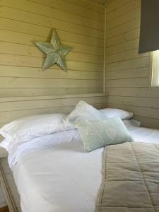 a bedroom with a bed with a star on the wall at Lakeside Shepard's Hut 'Sanderling' in Bishampton