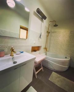 a bathroom with a tub and a sink and a bath tub at Villa Olymposzaray in Kumluca