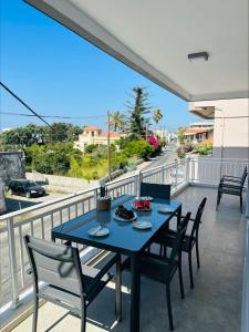 une table bleue et des chaises sur un balcon dans l'établissement Flev's Luxury House with pool, à Kremasti