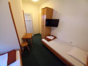 Habitación pequeña con cama y mesa pequeña. en Dom Plus, en Ovčar Banja