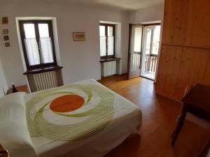 een kamer met een bed in een kamer met ramen bij Camera con vista in Calalzo