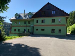 a large house with a large parking lot in front of it at Karlov pod Pradědem Apartmány Orbit in Karlov