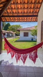 a red hammock hanging from a porch with a house at Village Miramar in Maragogi +105 photos