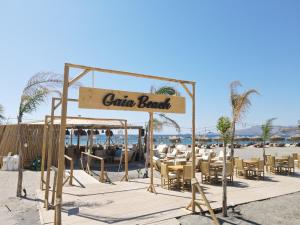 ein Schild für eine Gulum-Bar am Strand in der Unterkunft Alia Luxury Suites and Spa in Charaki