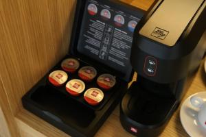 a black coffee maker with cupcakes in a box at The Oak Hotel in Keramotí