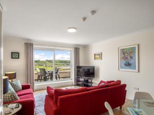 sala de estar con sofá rojo y TV en Stunning apartment Clifden en Clifden
