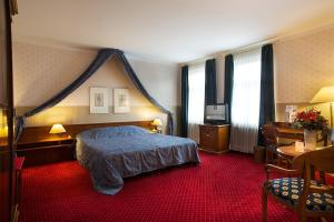Schlafzimmer mit einem Bett und einem roten Teppich in der Unterkunft Hotel Sächsischer Hof in Meiningen