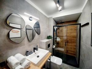 La salle de bains est pourvue d'un lavabo et d'une douche. dans l'établissement Kolory Warmii Apartamenty Garaż Podziemny-30pln-doba, à Olsztyn