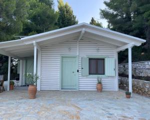 a white shed with a door and a porch at The White House above Egremni in Athani