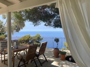 a table and chairs on a patio with a view of the ocean at The White House above Egremni in Athanion