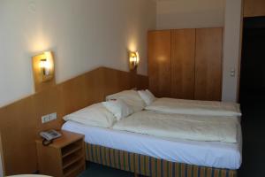 a bedroom with a bed with a wooden headboard at Evangelische Diakonissenanstalt Stuttgart in Stuttgart