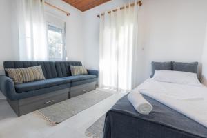 1 dormitorio con cama, sofá y ventana en KOUROUTA BEACH HOUSE, en Kourouta