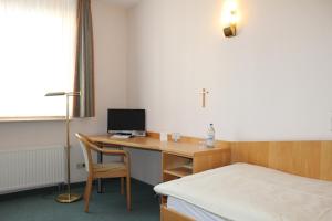 a room with a desk with a computer and a bed at Evangelische Diakonissenanstalt Stuttgart in Stuttgart