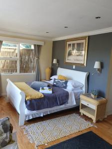 a bedroom with a large white bed and a rug at 18 On Thesen. in Knysna