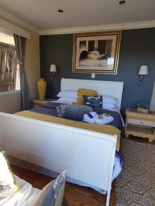 a bedroom with a large bed with blue walls at 18 On Thesen. in Knysna