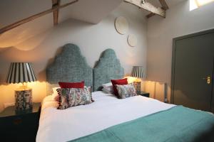 a bedroom with a large white bed with two lamps at The Ship Hotel in Brancaster